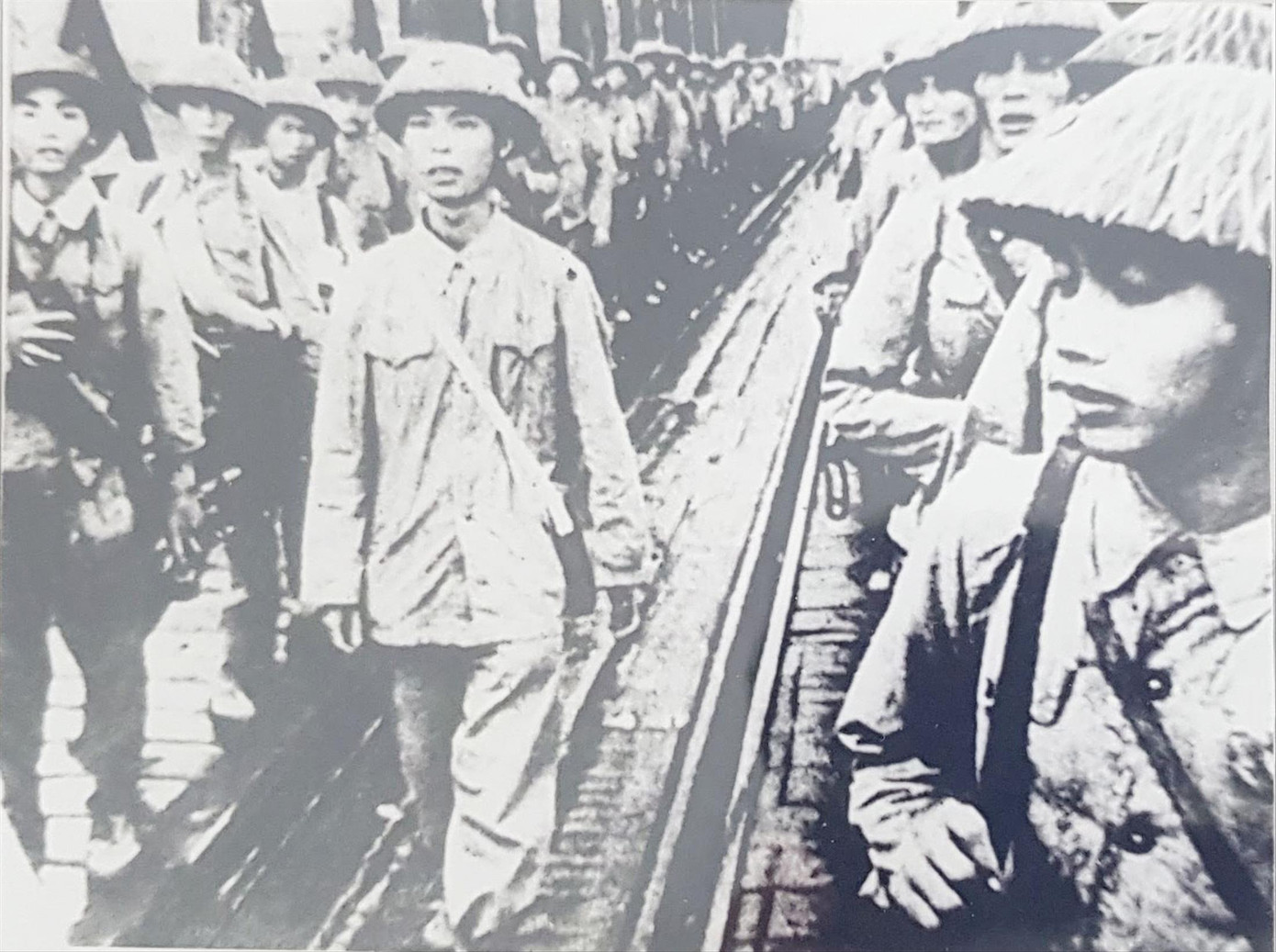 Chính trị viên Vũ Huy Hậu (đi giữa hàng quân) cùng Tiểu đoàn Bình Ca trên cầu Đuống về tiếp quản Thủ đô. Ảnh: T.L.