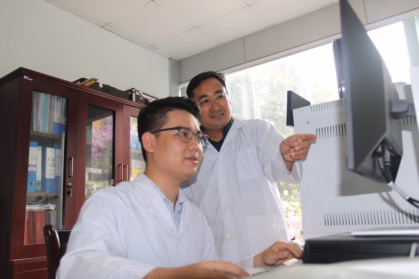 PGS.TS Trần Mạnh Trí (người đứng) hướng dẫn học trò nghiên cứu khoa học. Ảnh: Diệp An