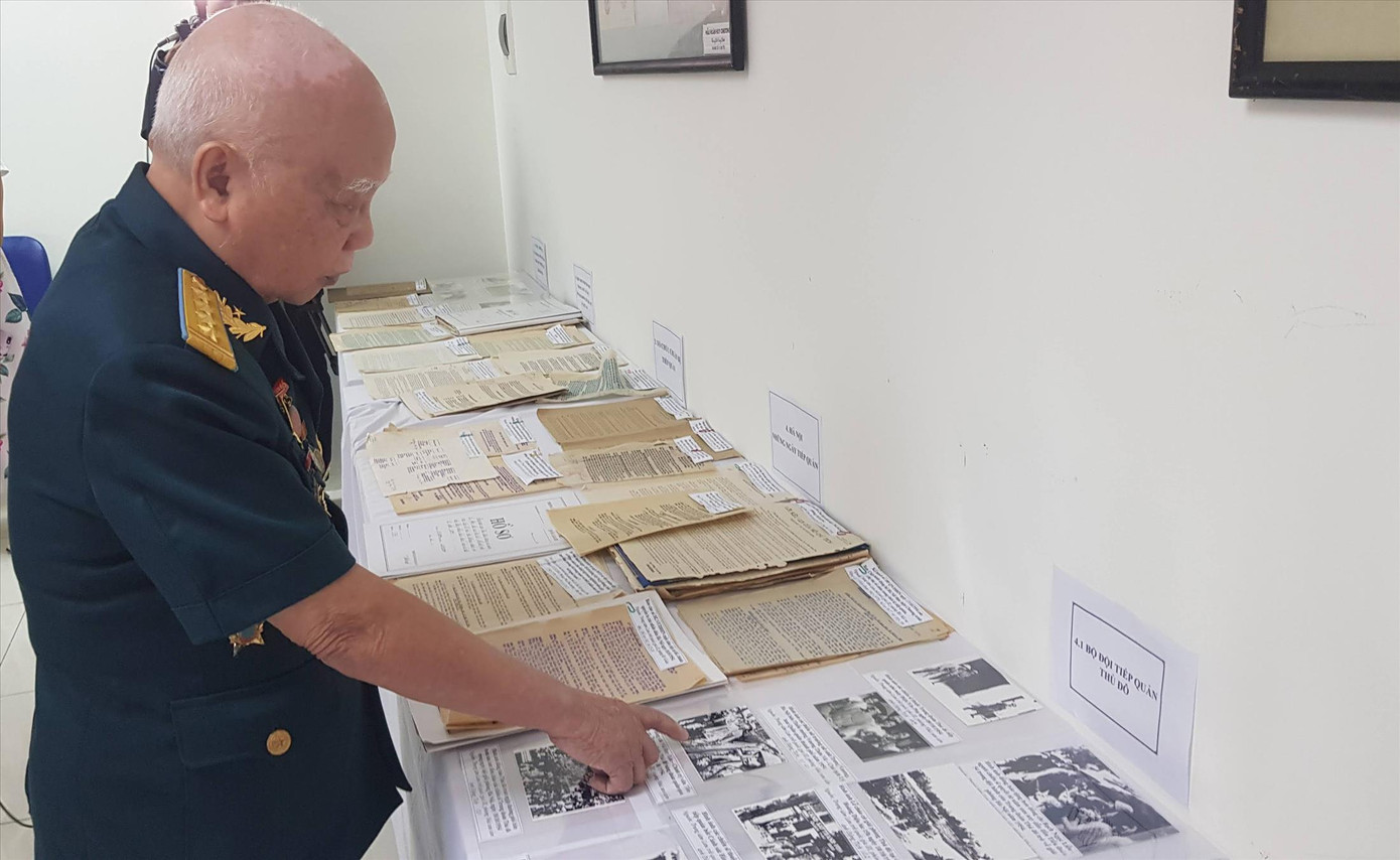 Đại tá Dương Niết chỉ bức ảnh Tiểu đoàn Bình Ca trên cầu Đuống khi về tiếp quản Thủ đô. Ảnh: K.N.