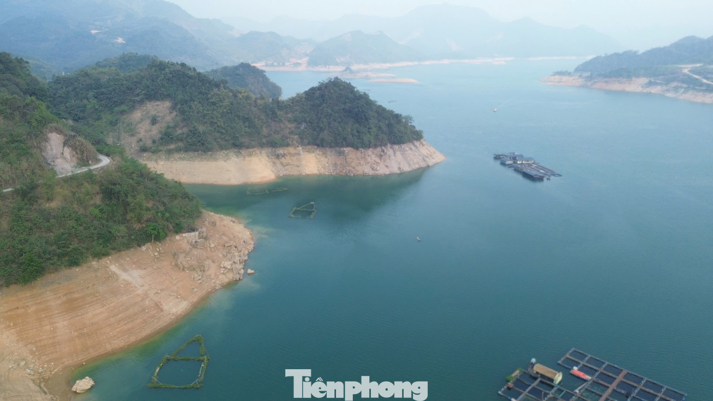 Do miền Bắc những tháng qua hầu như không có mưa lớn, mực nước lòng hồ thủy điện Hòa Bình hiện đã xuống thấp khoảng 30m so với cùng kỳ năm 2024. Nước hồ xuống thấp để lộ ra những bãi cát, vệt đất trắng, vàng men theo chân núi.