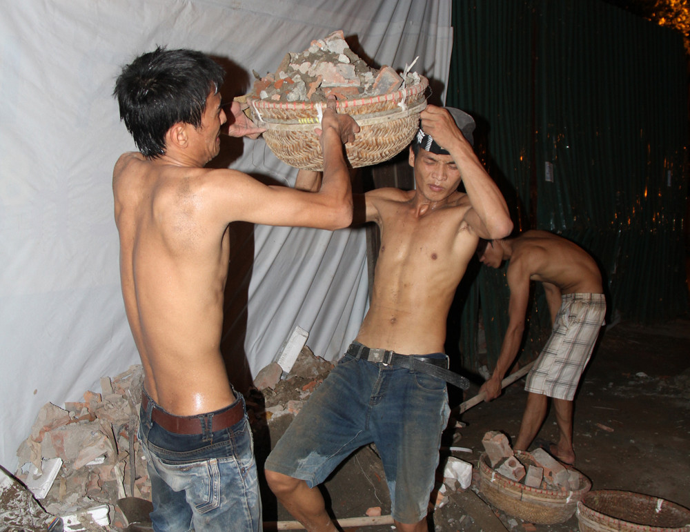 Mỗi thúng phế thải này khá nặng. Nam thanh niên tên Thảo cho biết, mỗi đêm, trung bình đội 300 thúng. Ảnh: Trường Phong