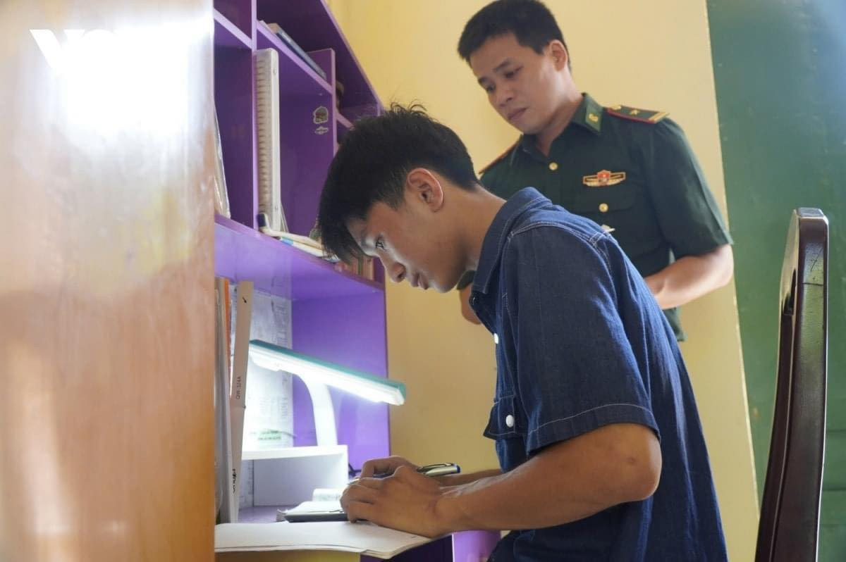 Vũ cùng cha nuôi tại Đồn biên phòng Roòn.