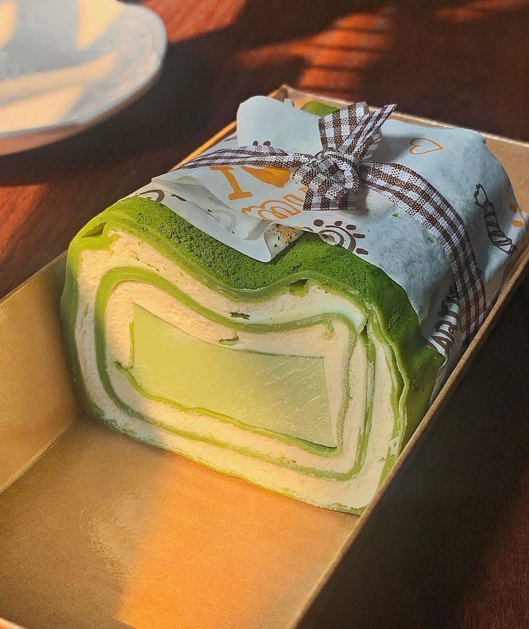 Bánh crepe pudding vị trà xanh được săn lùng nhiều hơn cả. Bánh thường được đặt trong hộp giấy nắp nhựa, trang trí bằng cách bọc giấy nến quanh bánh và buộc dây nơ. (Ảnh: Em_bakehous, Tales of Dino)