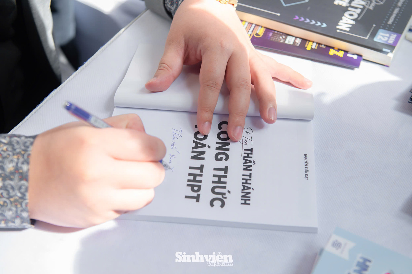 Thầy Nguyễn Tiến Đạt kí tặng sách cho các bạn học sinh.