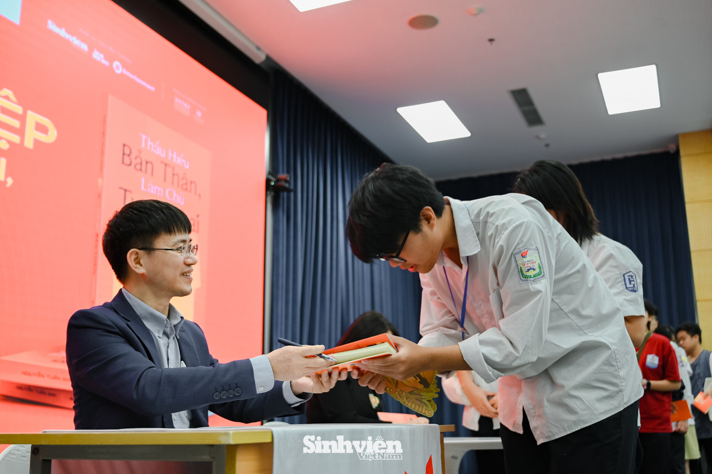 Nhà báo Nguyễn Tuấn Anh và diễn giả Nguyễn Mến kí tặng sách cho các bạn học sinh.