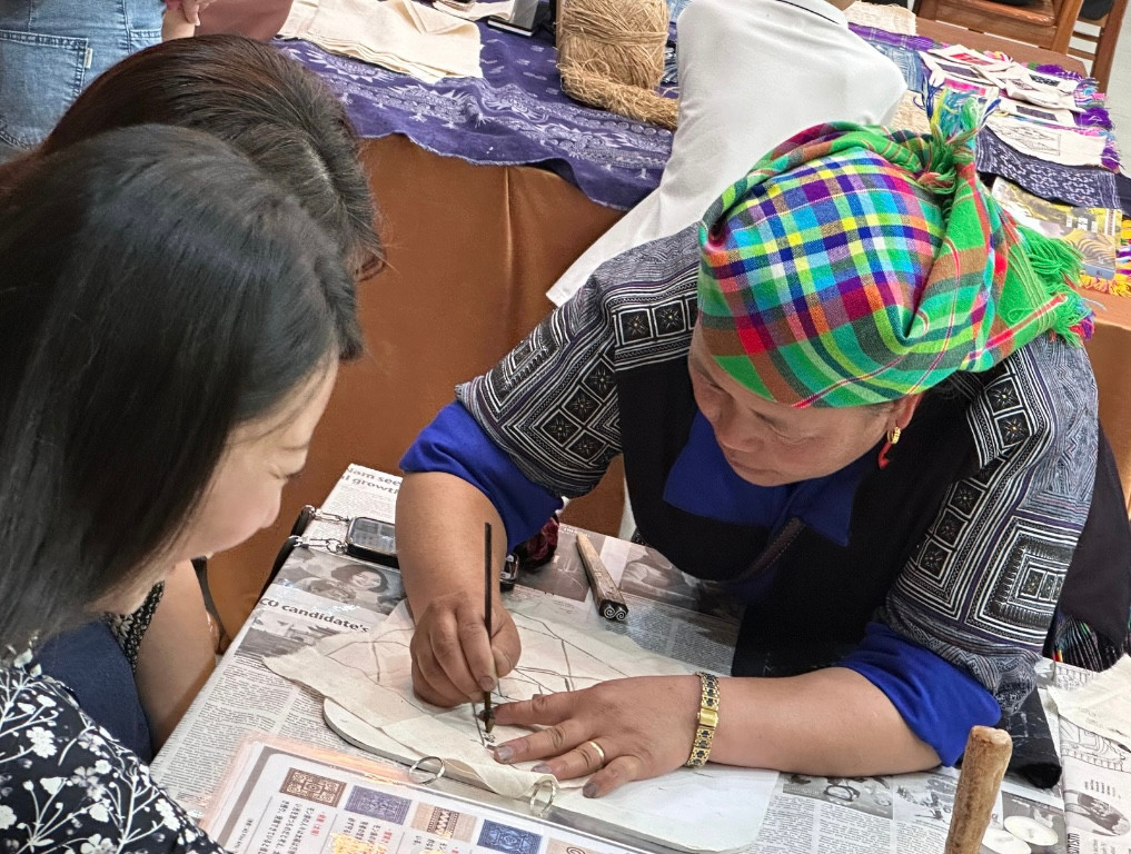 Người phụ nữ Mông dùng bút - một loại bút đặc biệt làm từ sừng hoặc xương của động vật, cán bút bằng tre hoặc gỗ, sau đó chấm sáp ong đang nóng chảy để vẽ hoa văn trên vải lanh. Người phụ nữ Mông dùng bút - một loại bút đặc biệt làm từ sừng hoặc xương của động vật, cán bút bằng tre hoặc gỗ, sau đó chấm sáp ong đang nóng chảy để vẽ hoa văn trên vải lanh.