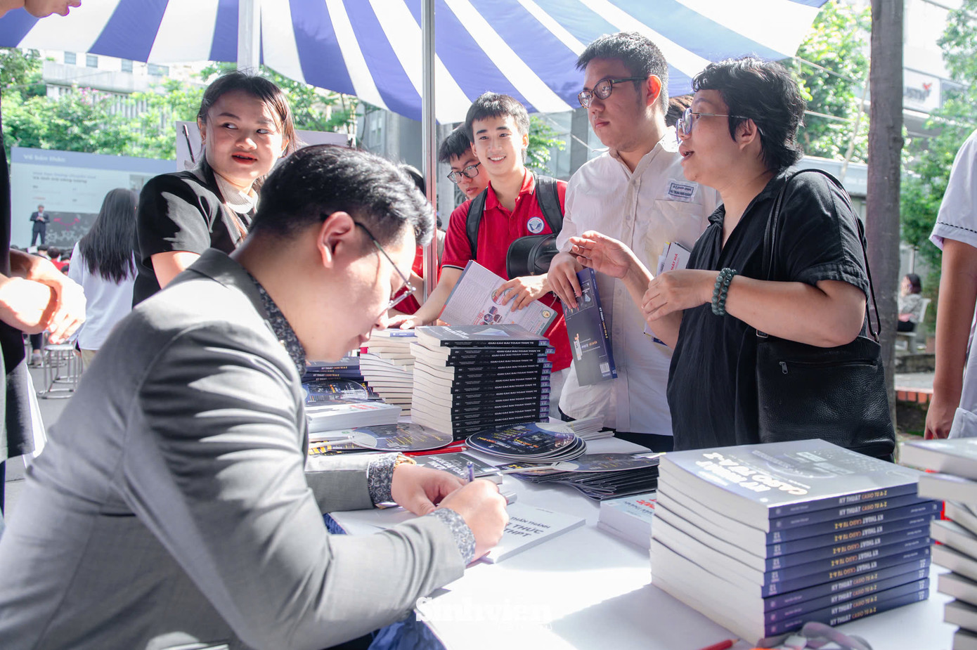 Thầy Nguyễn Tiến Đạt kí tặng sách cho các bạn học sinh.