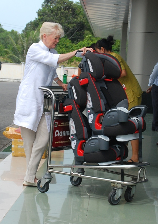 Hai chiếc ghế chuyên dùng dành cho 2 bé sinh đôi được người bảo mẫu đưa lên