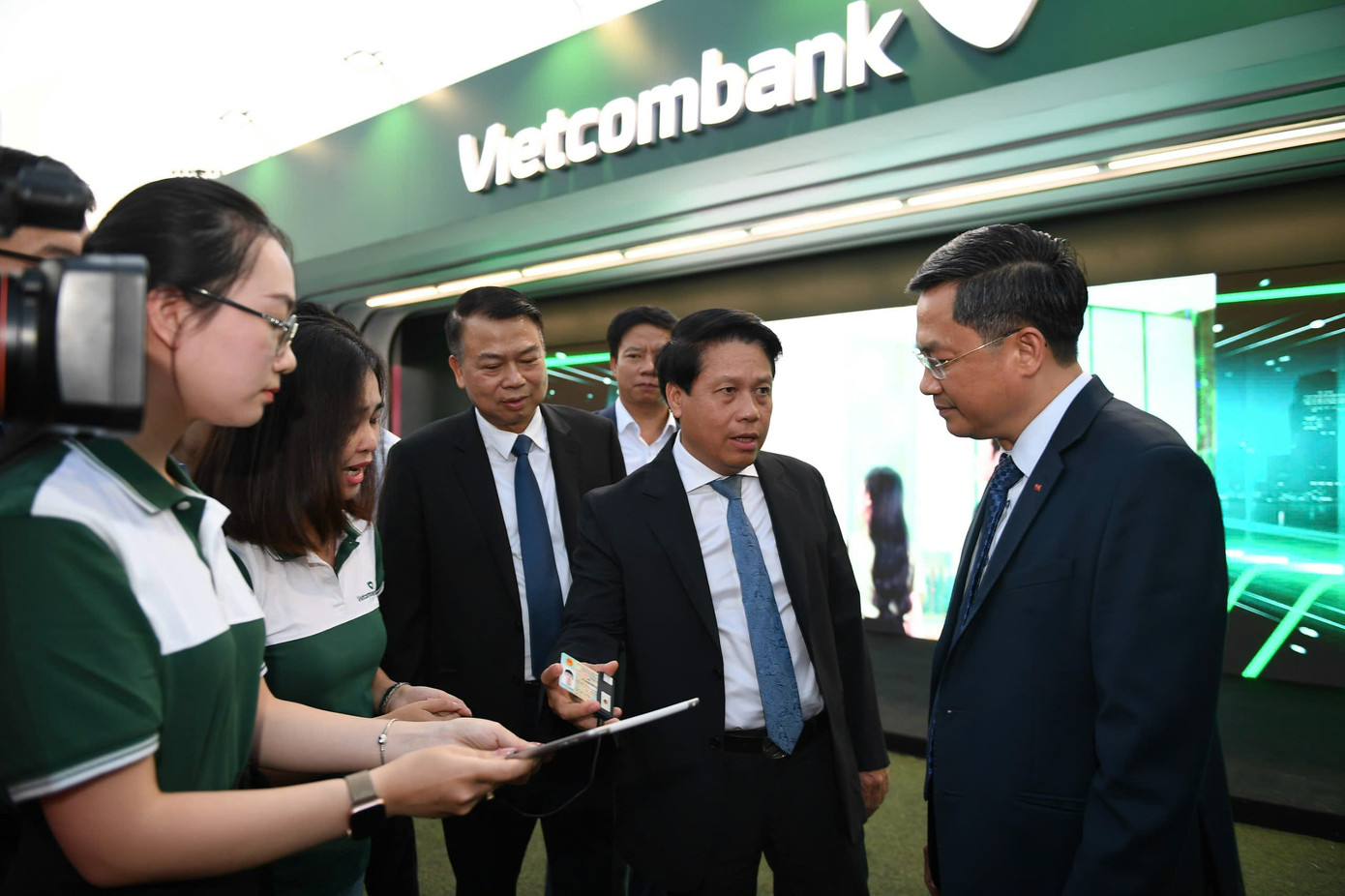 Đoàn đại biểu trải nghiệm công nghệ xác thực tự động căn cước công dân tại gian hàng Ngân hàng Vietcombank.