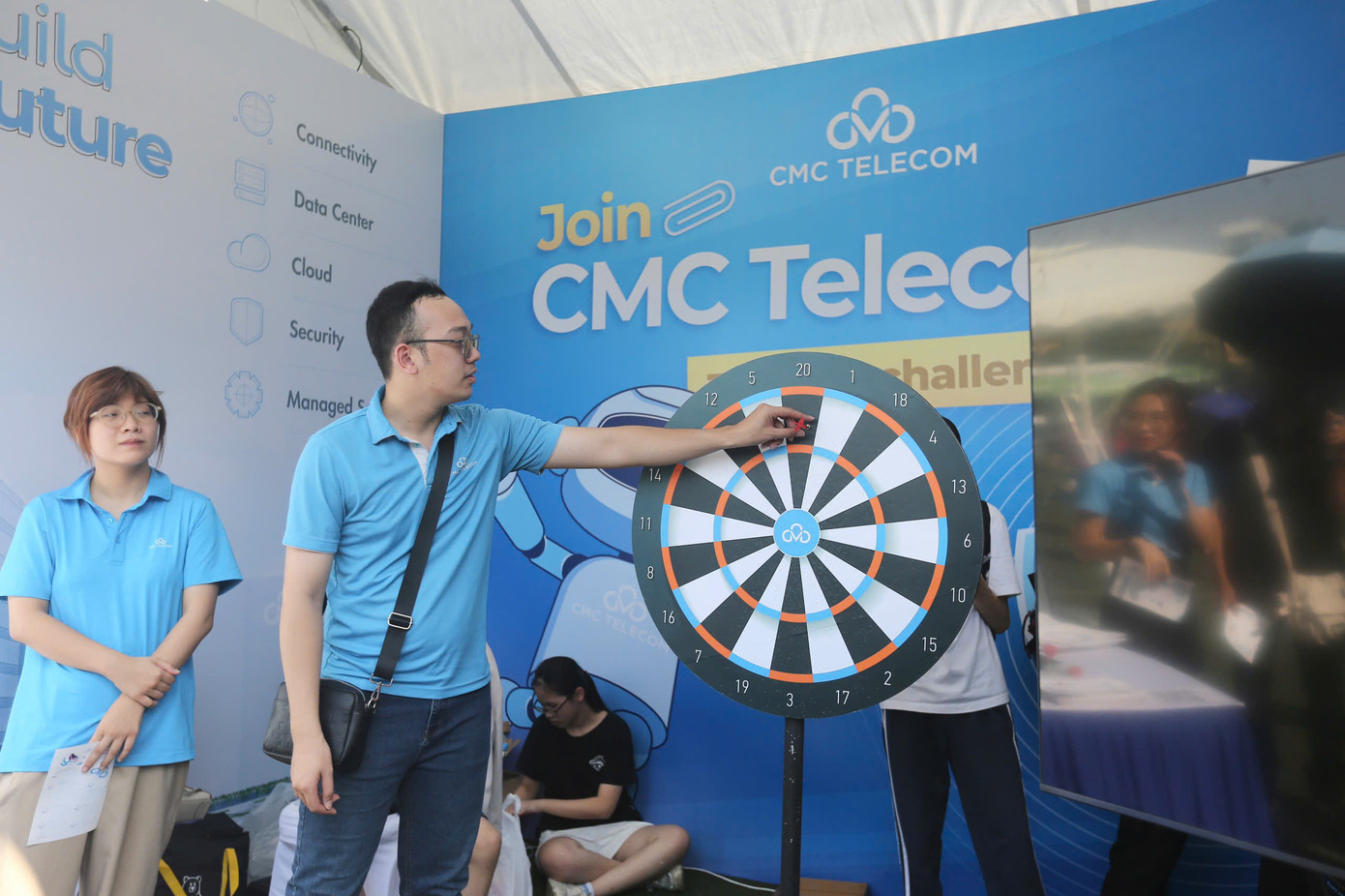 Nhân viên của CMC hướng dẫn trò chơi phi tiêu nhận quà.