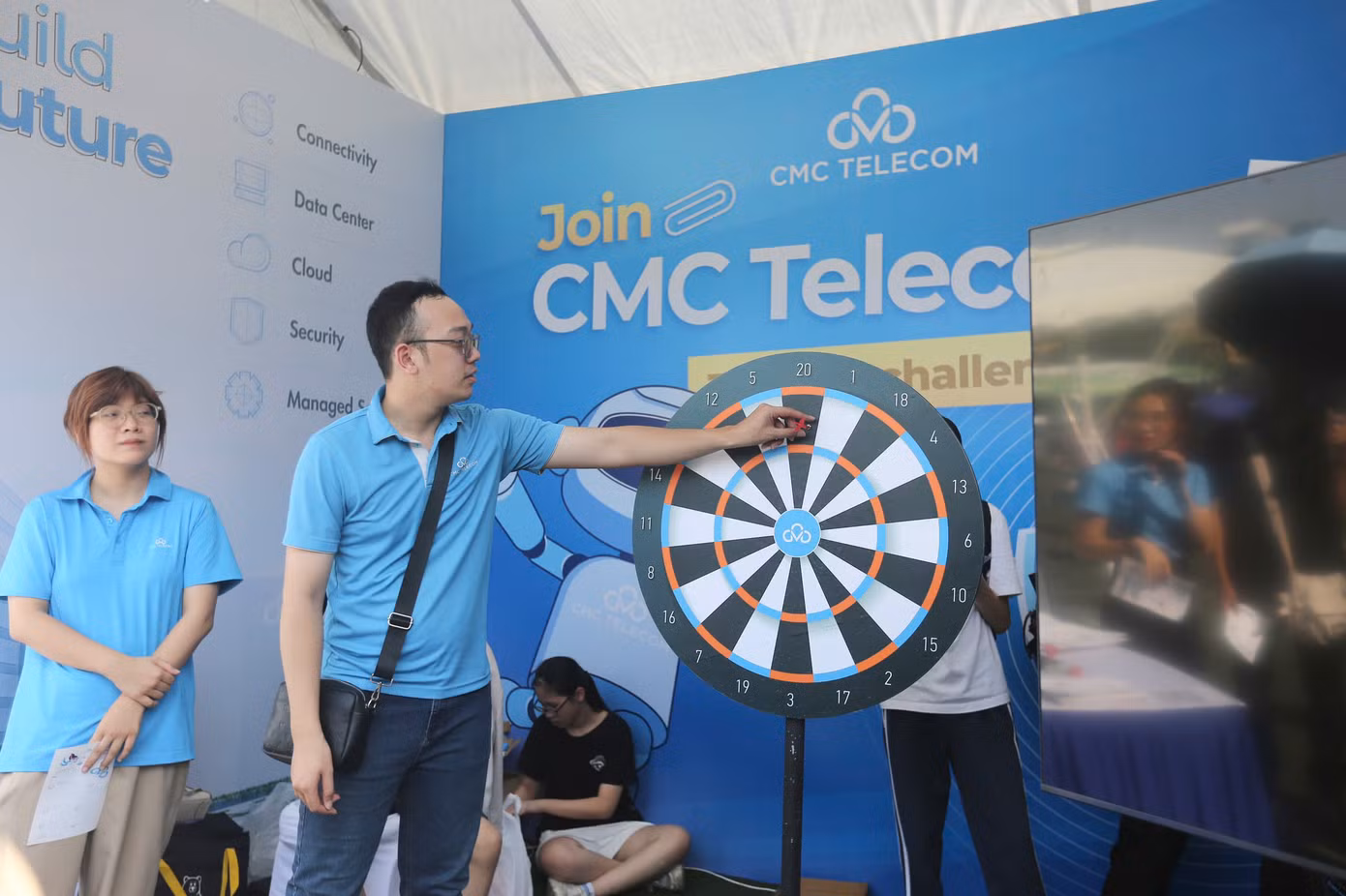 Nhân viên của CMC hướng dẫn trò chơi phi tiêu nhận quà.