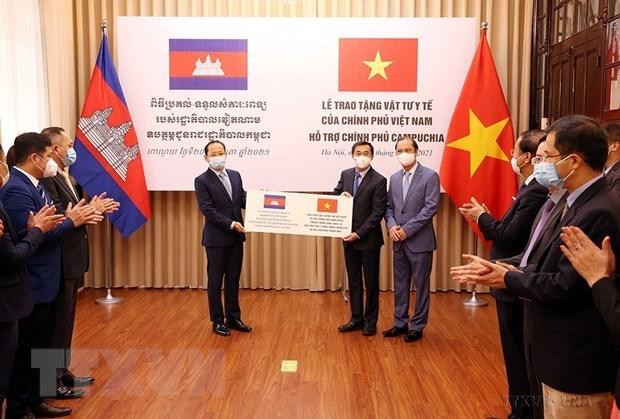 Thứ trưởng Bộ Y tế Trần Văn Thuấn và Thứ trưởng Bộ Ngoại giao Nguyễn Quốc Dũng trao tượng trưng vật tư y tế của Chính phủ Việt Nam cho Đại sứ Campuchia tại Việt Nam Chay Navuth, chiều 20/5/2021, tại Hà Nội. (Ảnh: Phạm Kiên/TTXVN).