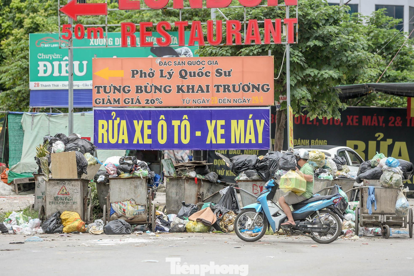 Hàng dài xe gom rác chở đầy rác thải được gom vào một chỗ, bốc mùi nồng nặc.