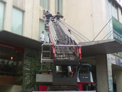 Lực lượng Cảnh sát PCCC dùng xe thang chuyên dụng đưa nạn nhân xuống