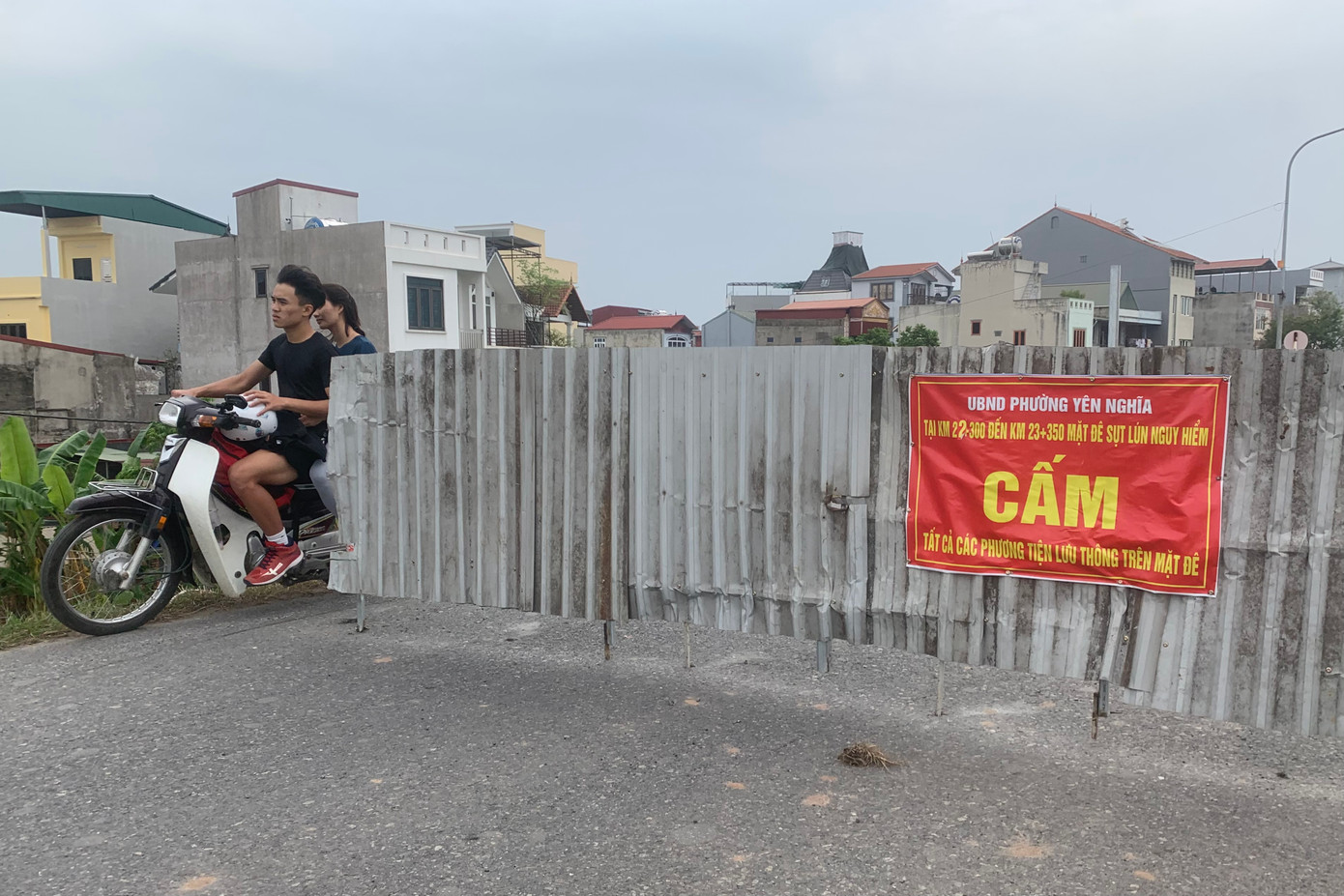 Nhiều phương tiện xe máy bất chấp nguy hiểm, vượt rào, băng qua đoạn đê đang bị sụt lún nghiêm trọng.