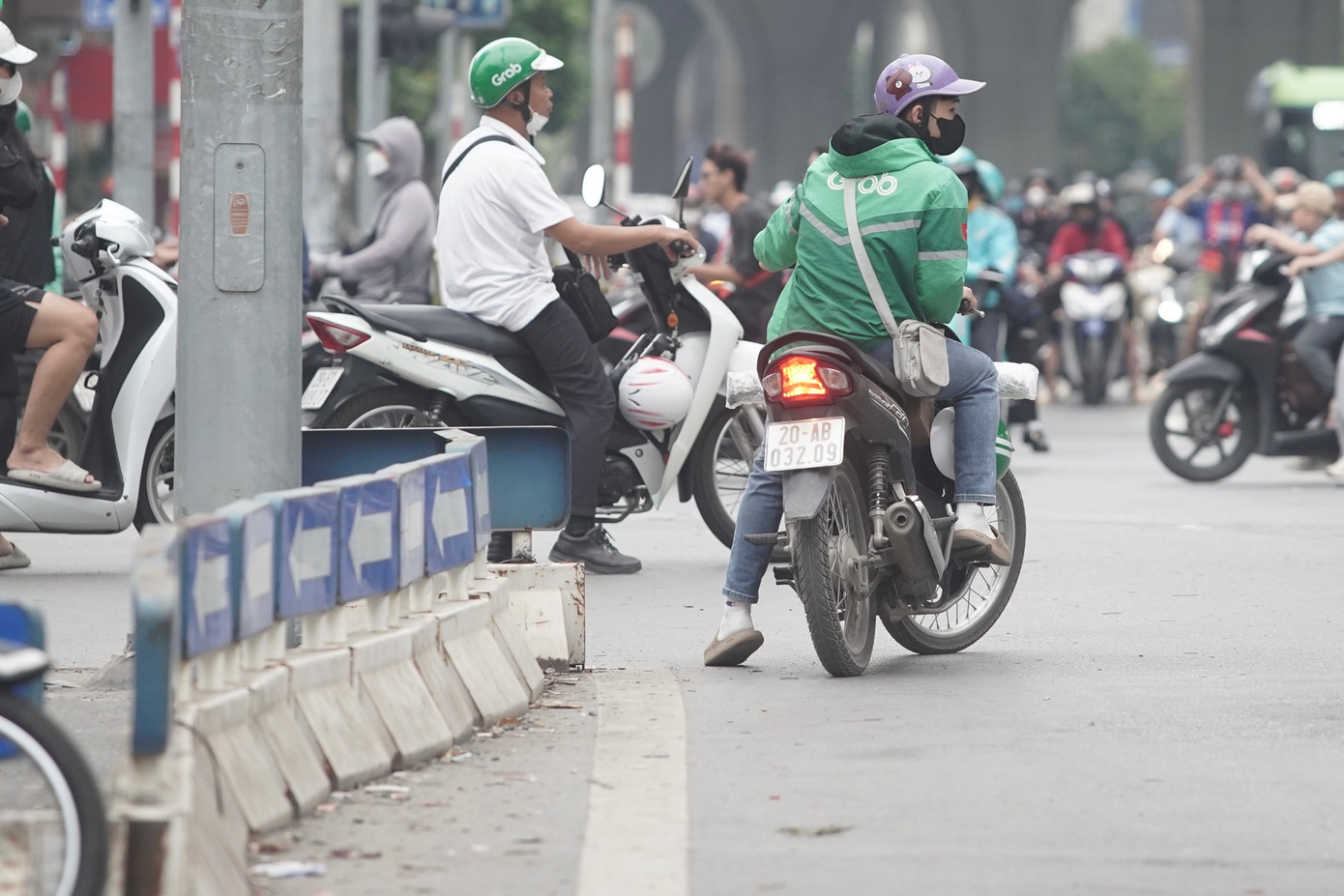 Tài xế xe ôm công nghệ mặc áo hãng Grab chạy ngược chiều trên đường Trường Chinh.