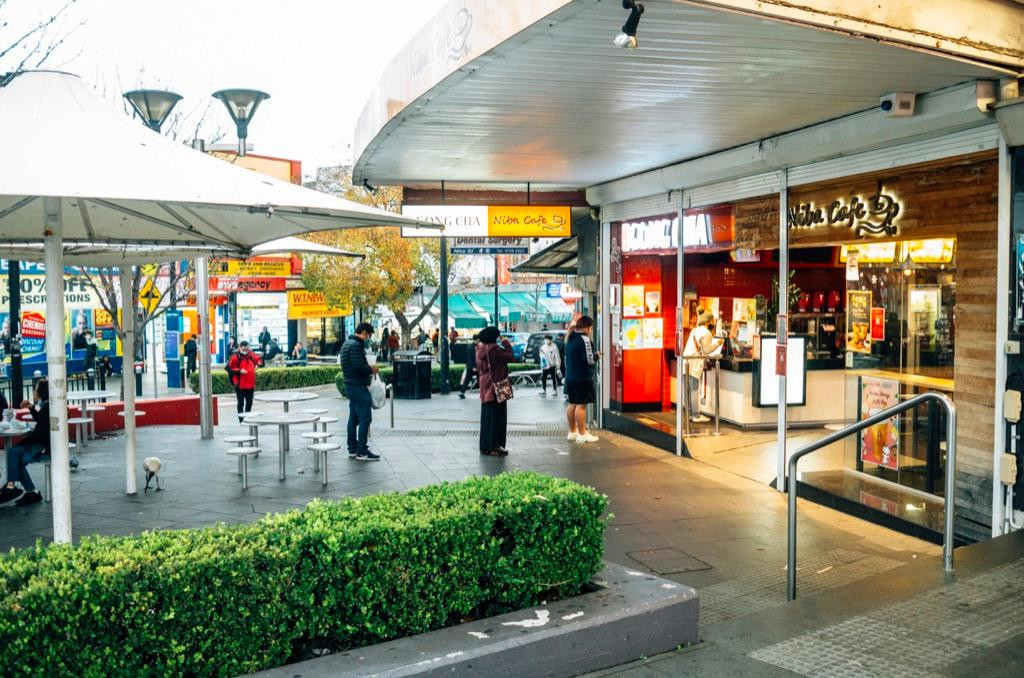 Các khách hàng giữ khoảng cách an toàn, xếp hàng chờ mua trà sữa mang đi.