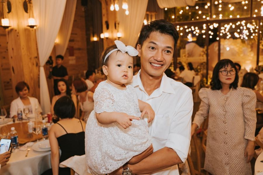 Quang Tuấn ẵm con gái trong tiệc thôi nôi Quang Tuấn ẵm con gái trong tiệc thôi nôi