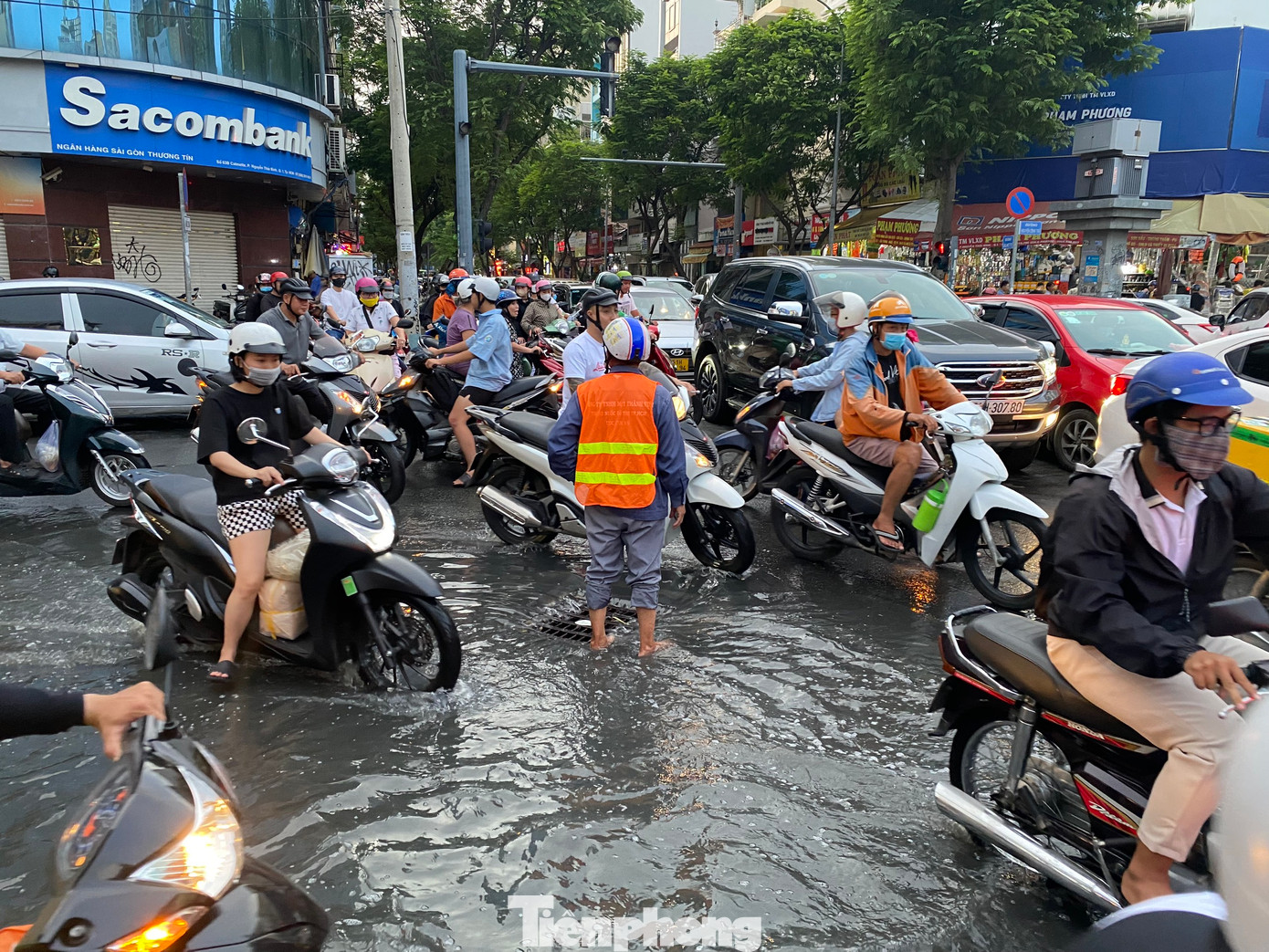 Nhân viên Công ty Thoát nước đô thị túc trực ở miệng cống để vớt rác, khơi thông dòng chảy, đồng thời, hỗ trợ điều tiết giao thông qua khu vực.
