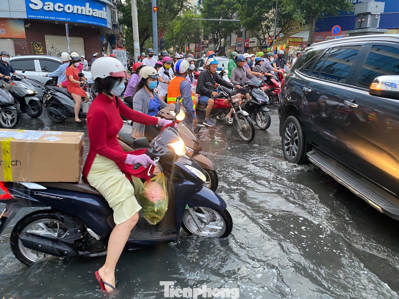 Người dân chật vật lưu thông qua khu vực ngập úng trong giờ tan tầm.