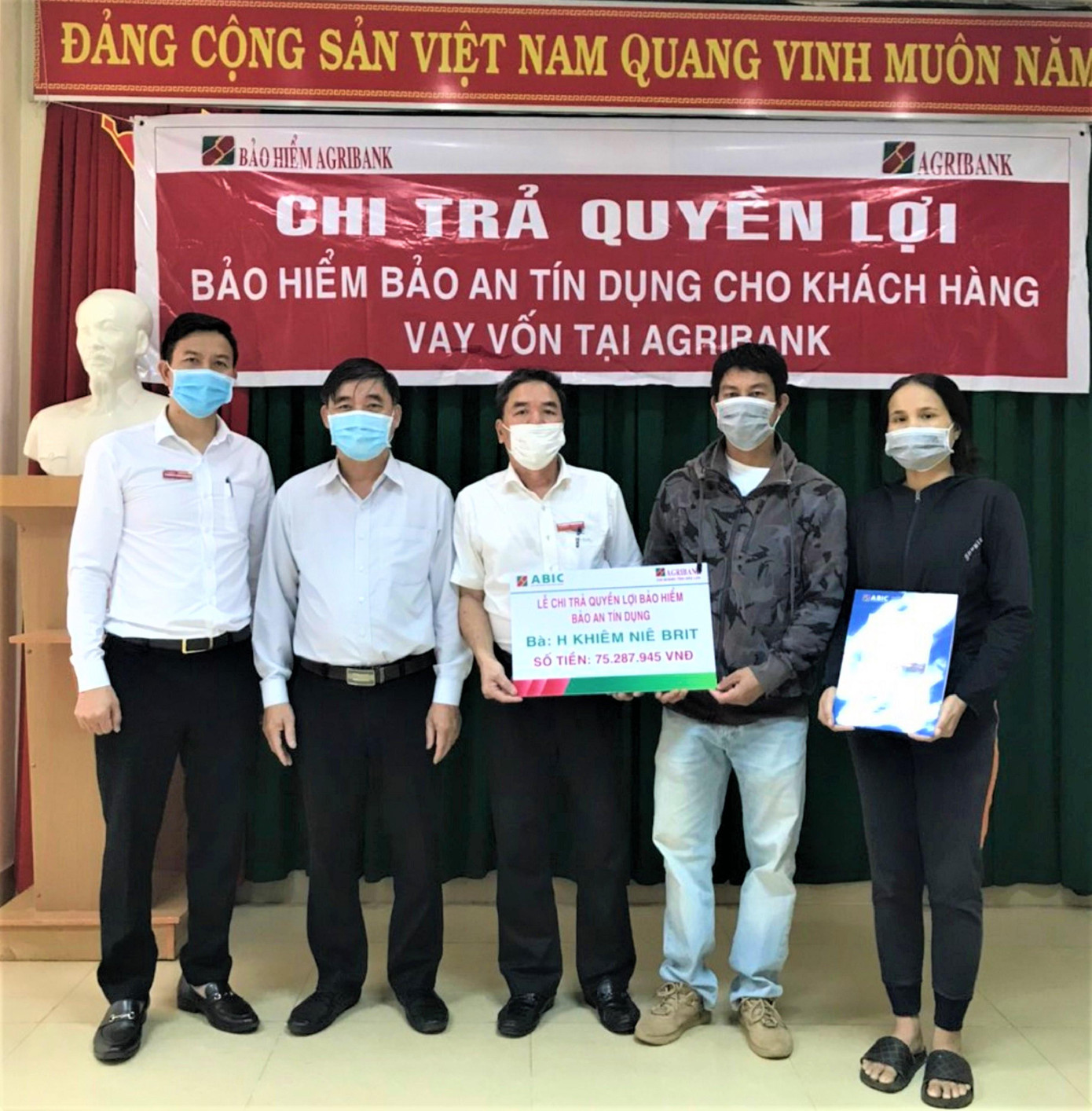 Đại diện Bảo hiểm Agribank Chi nhánh Đắk Lắk trao tiền cho khách hàng