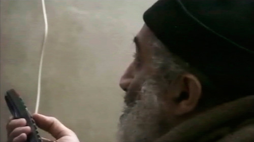 Bin Laden xem tin tức về chính mình trên tivi, ảnh được chụp từ một đoạn video do Nhà Trắng (Mỹ) công bố ngày 7-5. Ảnh: Reuters