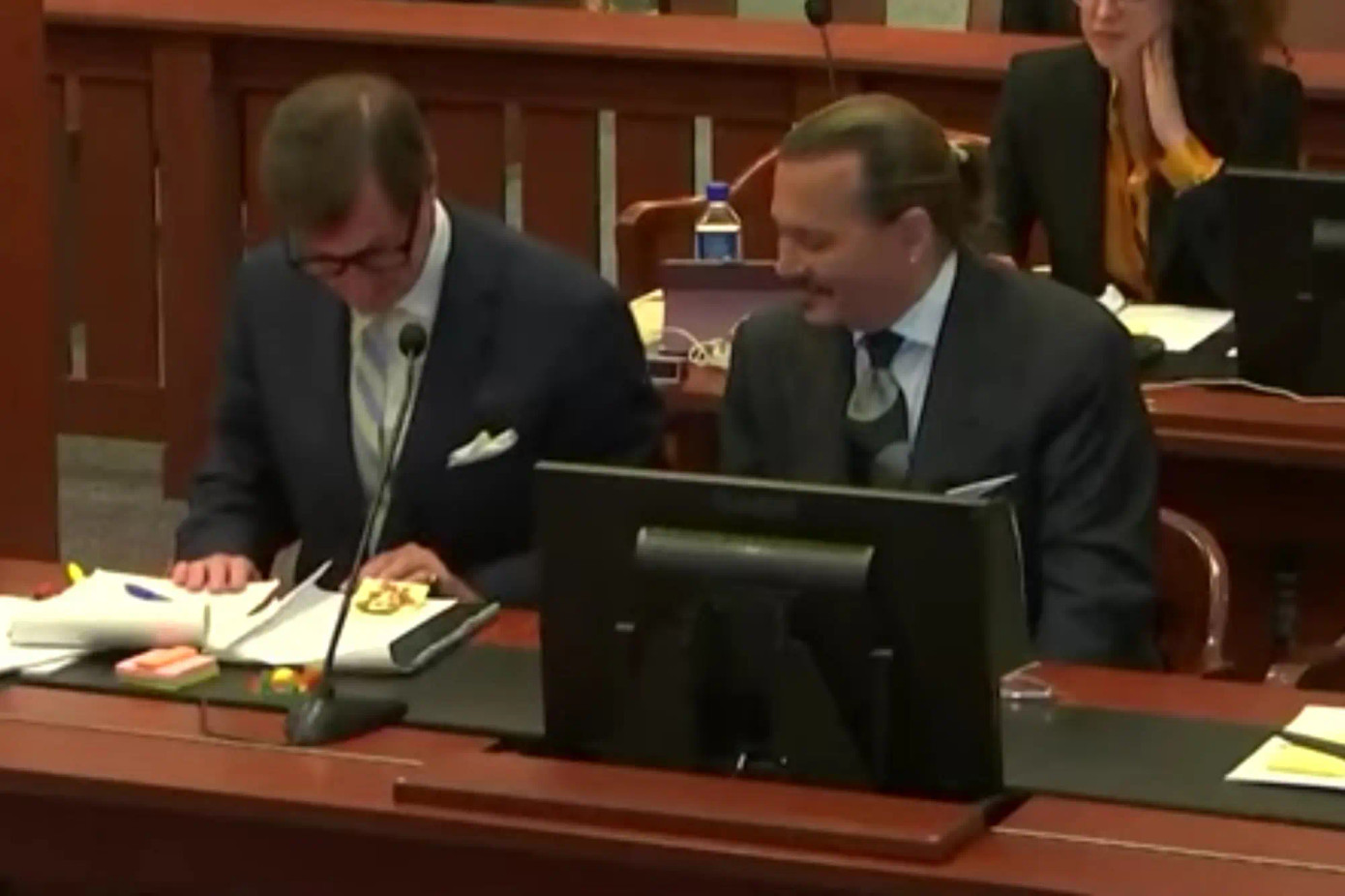 Luật sư đã đeo kính vào để xem kỹ bức tranh chân dung trên giấy ghi chú.