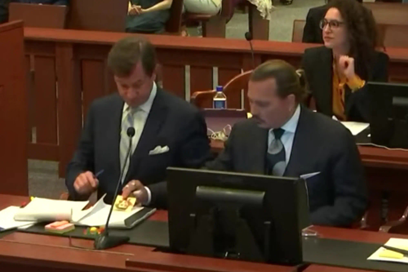 Johnny Depp cho luật sư riêng xem bức tranh phác thảo một phụ nữ do anh ngẫu hứng vẽ.