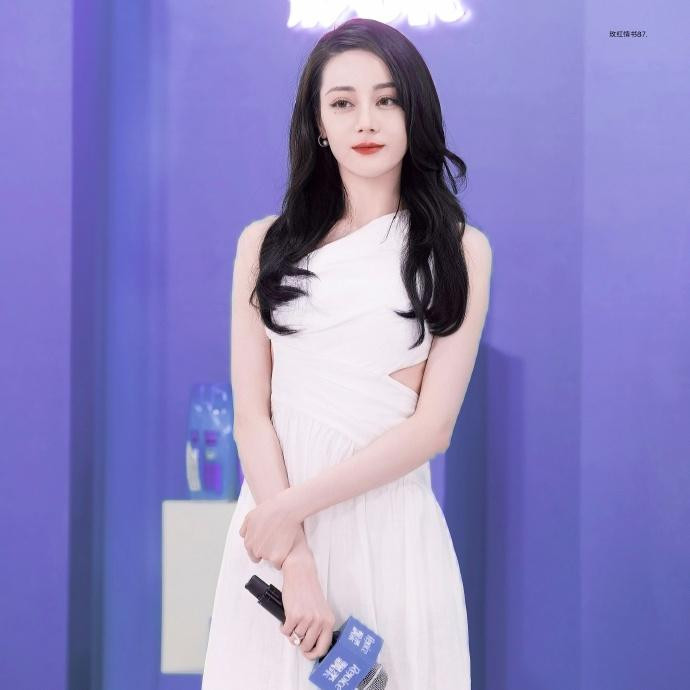 Đến chương trình, mỹ nhân Tân Cương mặc váy trắng lệch vai. Kết hợp với mái tóc xoăn gợn sóng, cô trông tao nhã, nữ tính, trưởng thành mà không kém phần gợi cảm.