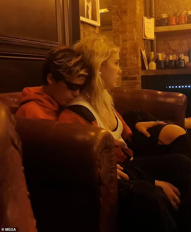 Cruz hôn vai, đặt tay vào đùi cô gái.