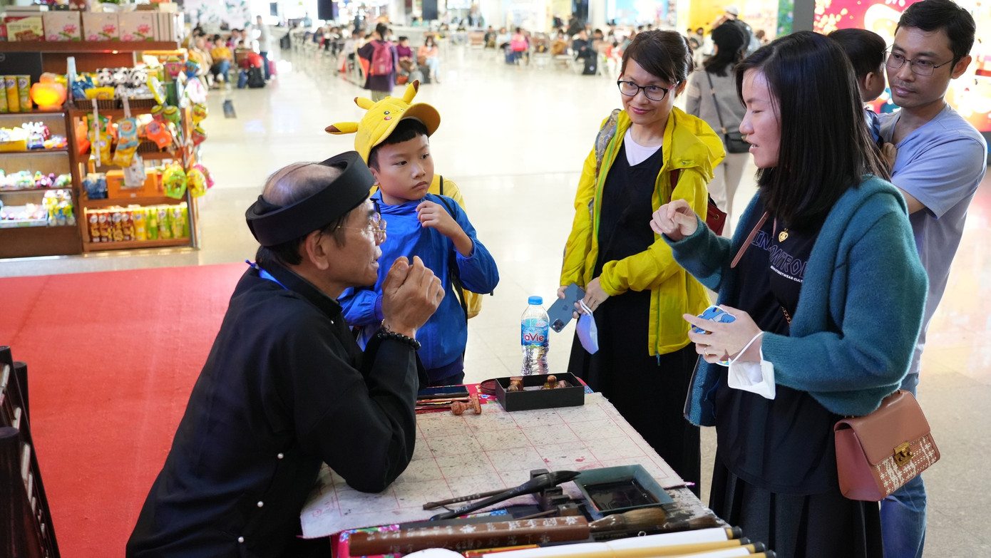 Nhiều người kiên nhẫn xếp hàng chờ tới lượt được thầy tặng chữ, đồng thời được thầy đồ phân tích, chia sẻ về ý nghĩa sâu xa của những bức thư pháp. Ảnh: NIA.