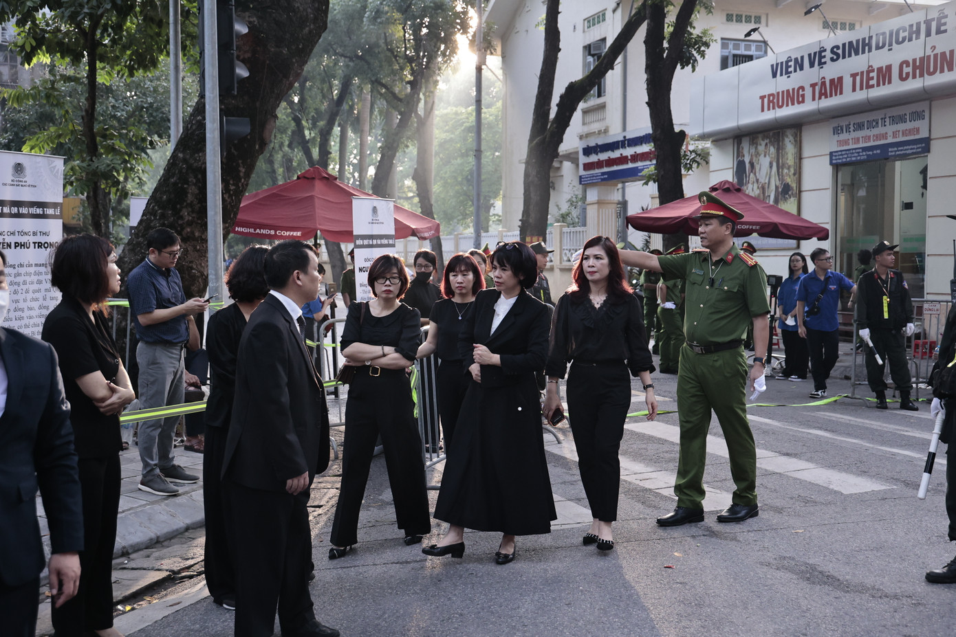 Lực lượng chức năng hướng dẫn người dân xếp hàng chờ đợi thông báo thời gian vào viếng Tổng Bí thư Nguyễn Phú Trọng. Ảnh: Như Ý.