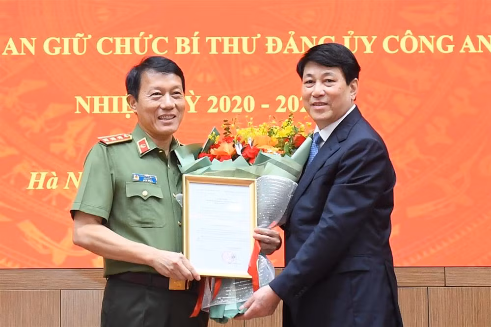 Thường trực Ban Bí thư Lương Cường trao quyết định và tặng hoa chúc mừng tân Bí thư Đảng uỷ Công an Trung ương. Ảnh: PV.