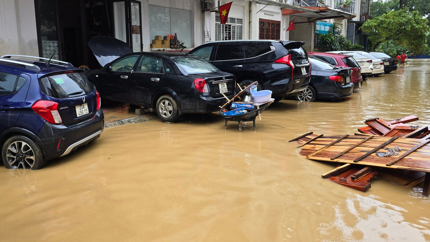 Người dân dọn dẹp, rửa xe ô tô bị ngập trong lũ. Ảnh: Hoàng Mạnh Thắng.