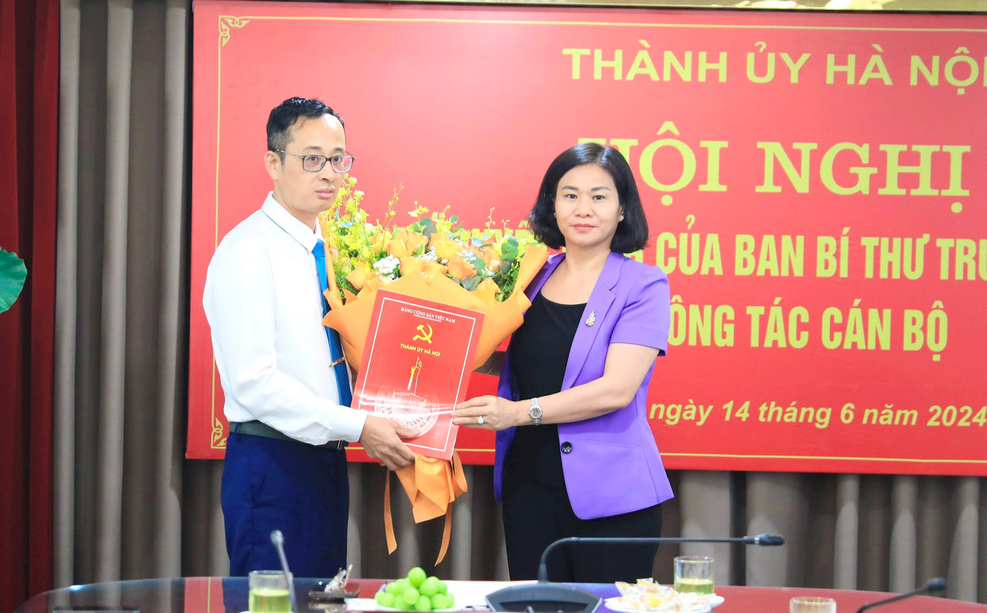 Phó Bí thư Thường trực Thành ủy Hà Nội Nguyễn Thị Tuyến trao Quyết định của Ban Bí thư T.Ư Đảng và tặng hoa chúc mừng ông Hoàng Văn Toái. Ảnh: HNM.