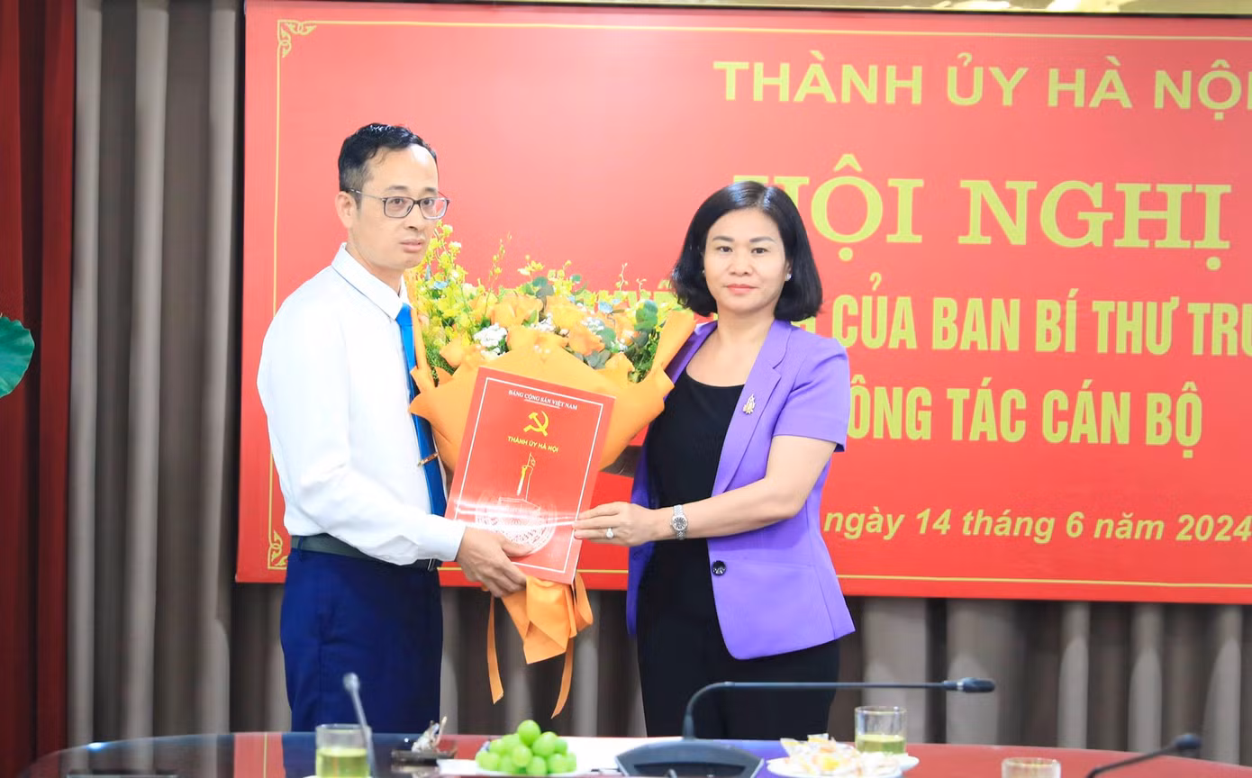 Phó Bí thư Thường trực Thành ủy Hà Nội Nguyễn Thị Tuyến trao Quyết định của Ban Bí thư T.Ư Đảng và tặng hoa chúc mừng ông Hoàng Văn Toái. Ảnh: HNM.