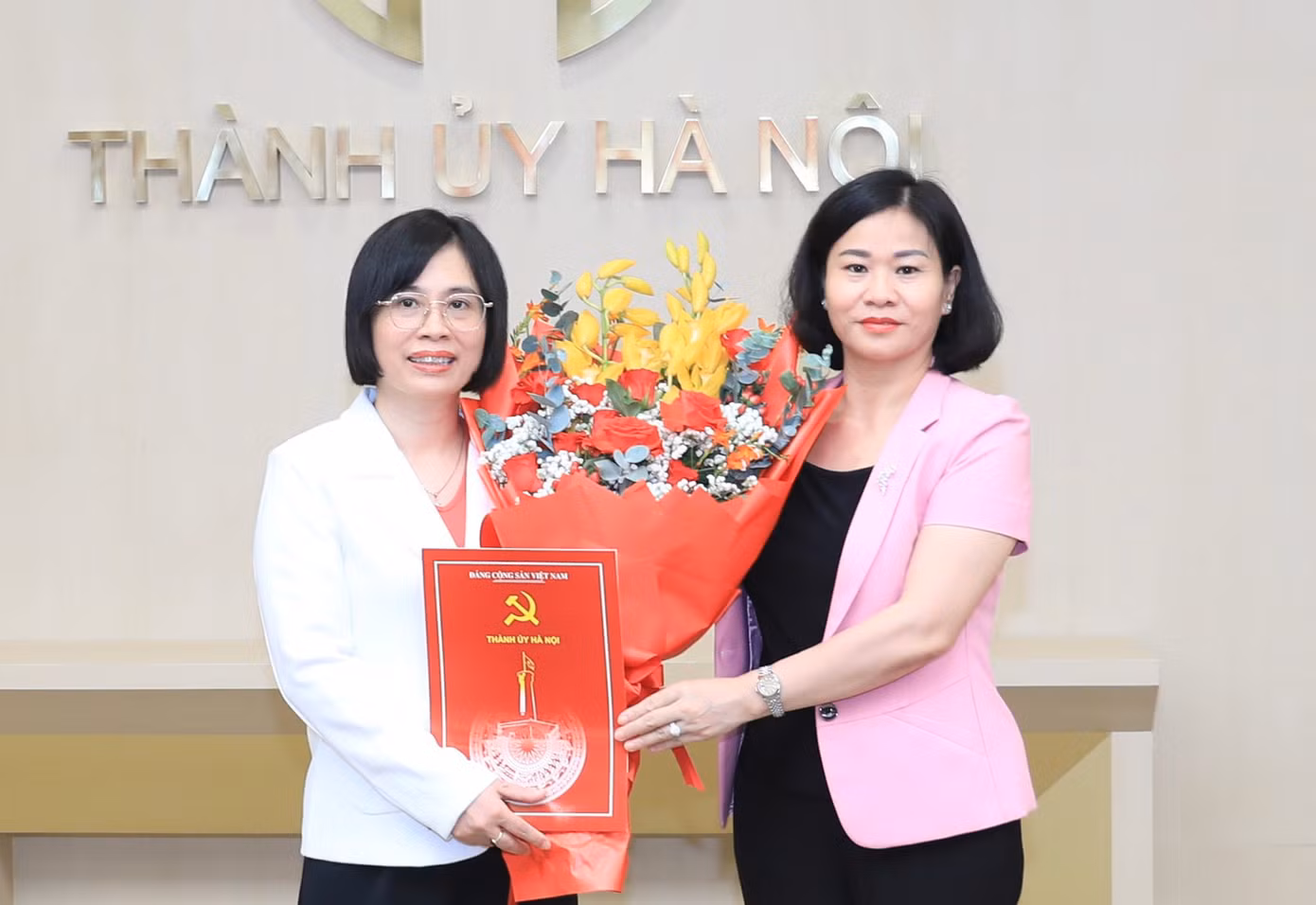 Phó Bí thư Thường trực Thành ủy Hà Nội Nguyễn Thị Tuyến trao quyết định và tặng hoa đồng chí Nguyễn Thị Thu Thủy. Ảnh: HNM.