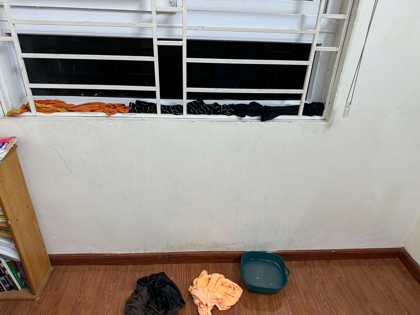 Anh Chung phải chèn khăn, quần áo cũ để ngăn nước chảy vào nhà qua khe cửa sổ. Ảnh: NVCC.