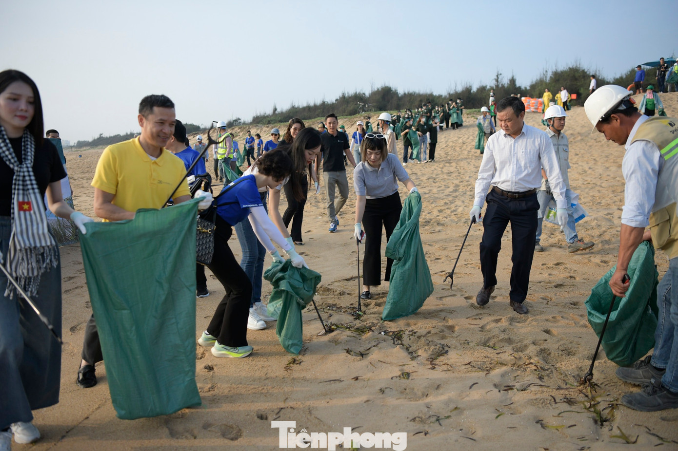 Các đại biểu dọn dẹp rác trên bãi biển.