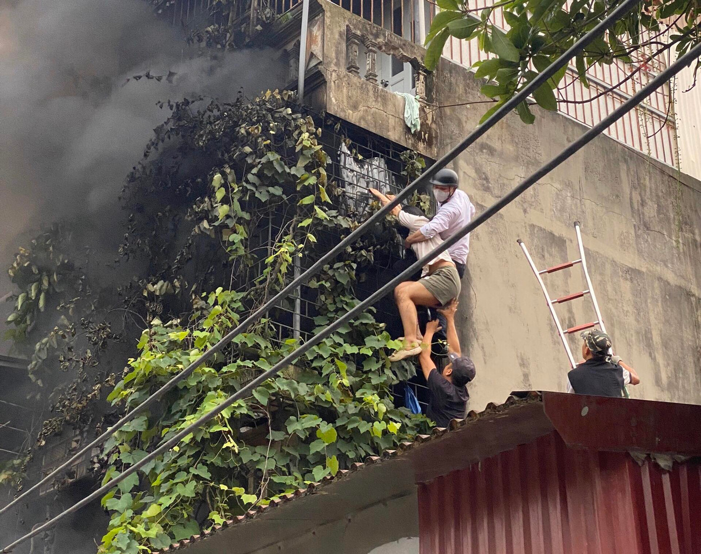 Khoảnh khắc anh Lèng Văn Bằng (áo trắng) hỗ trợ cứu nạn nhân mắc kẹt trong vụ cháy ở quận Hà Đông. Ảnh: PV Khoảnh khắc anh Lèng Văn Bằng (áo trắng) hỗ trợ cứu nạn nhân mắc kẹt trong vụ cháy ở quận Hà Đông. Ảnh: PV