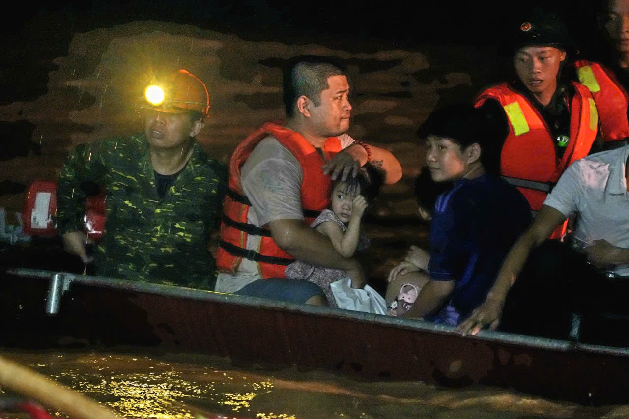 Một gia đình trong đó có cháu nhỏ được đưa ra khỏi vùng lũ lụt. Ảnh: Hoàng Mạnh Thắng. Một gia đình trong đó có cháu nhỏ được đưa ra khỏi vùng lũ lụt. Ảnh: Hoàng Mạnh Thắng.