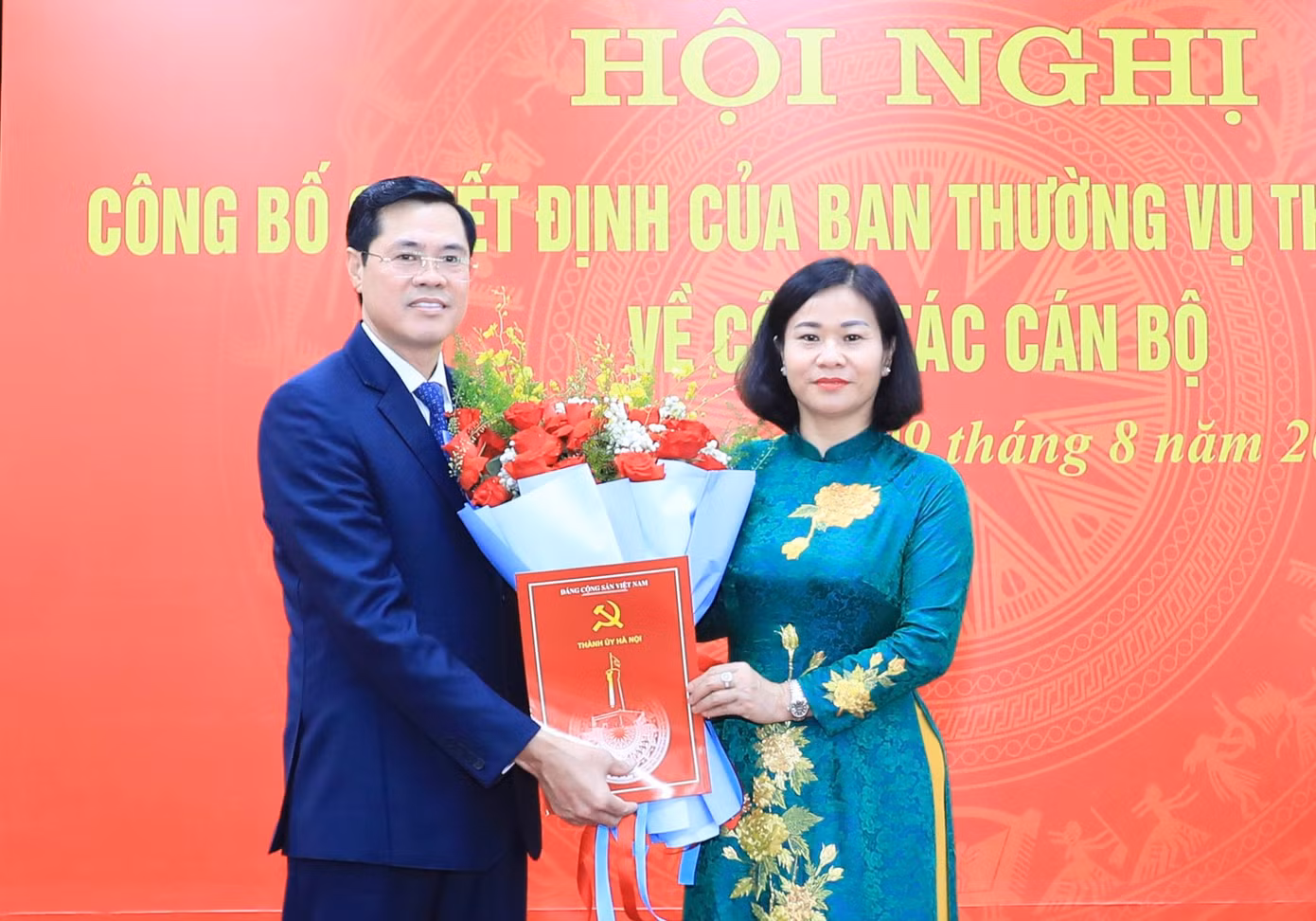Phó Bí thư Thường trực Thành uỷ Hà Nội Nguyễn Thị Tuyến trao quyết định và tặng hoa chúc mừng ông Nguyễn Xuân Phong. Ảnh: PV