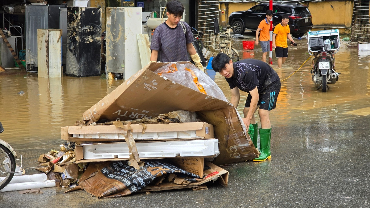 Người dân tranh thủ dọn dẹp nhà cửa, rác thải sau nhiều ngày bị ngập bởi nước lũ. Ảnh: Hoàng Mạnh Thắng.