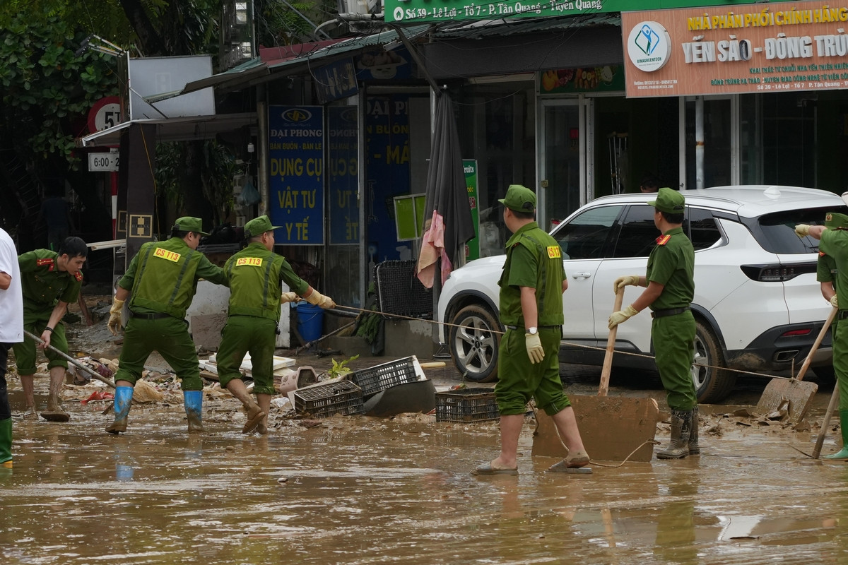 Lực lượng công an thành phố Tuyên Quang cùng với người dân dọn dẹp phố phường sau lũ. Ảnh: Hoàng Mạnh Thắng.