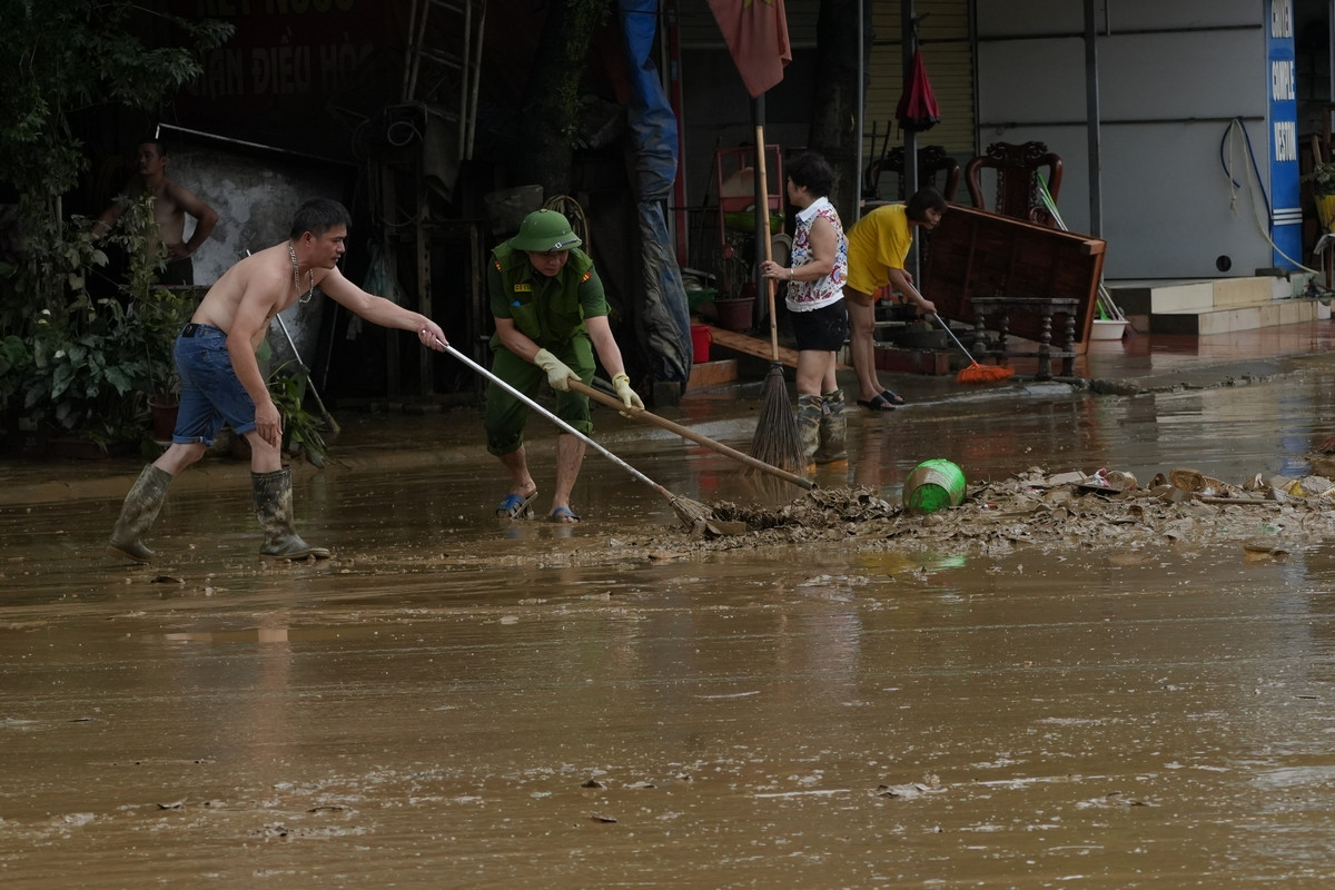 Lực lượng công an thành phố Tuyên Quang cùng với người dân dọn dẹp phố phường sau lũ. Ảnh: Hoàng Mạnh Thắng.