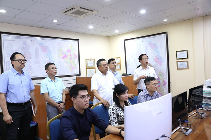 Chủ tịch UBND thành phố Hà Nội Trần Sỹ Thanh và lãnh đạo các sở ngành kiểm tra hoạt động của Trung tâm Giám sát hệ thống thoát nước tại Công ty TNHH MTV Thoát nước Hà Nội. Ảnh: PV.