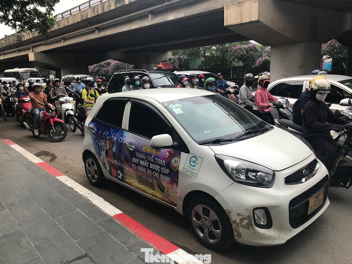 Một chiếc xe taxi dán logo quảng cáo web cá cược bóng đá ven đường Vành đai 3, khu vực phường Hoàng Liệt (Hoàng Mai, Hà Nội). Ảnh: Trường Phong.