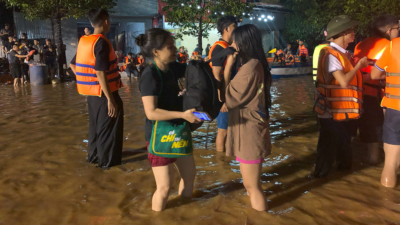 Nhiều người dân được cứu trợ ra khỏi khu vực bị ảnh hưởng lũ lụt lúc nửa đêm. Ảnh: Hoàng Mạnh Thắng