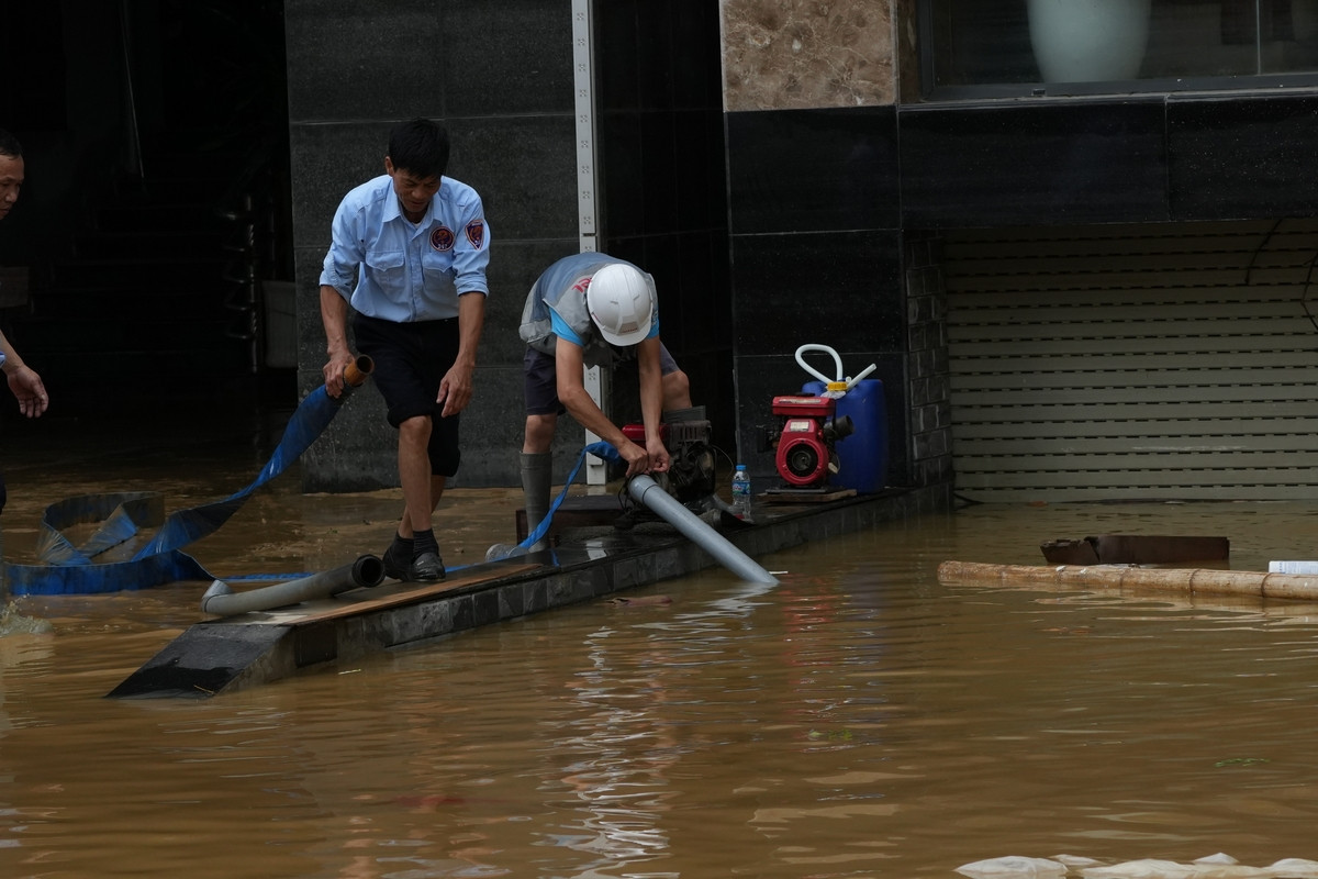 Người dân cố gắng dọn dẹp nhà cửa, hút nước khỏi những khu vực còn ngập sâu. Ảnh: Hoàng Mạnh Thắng.