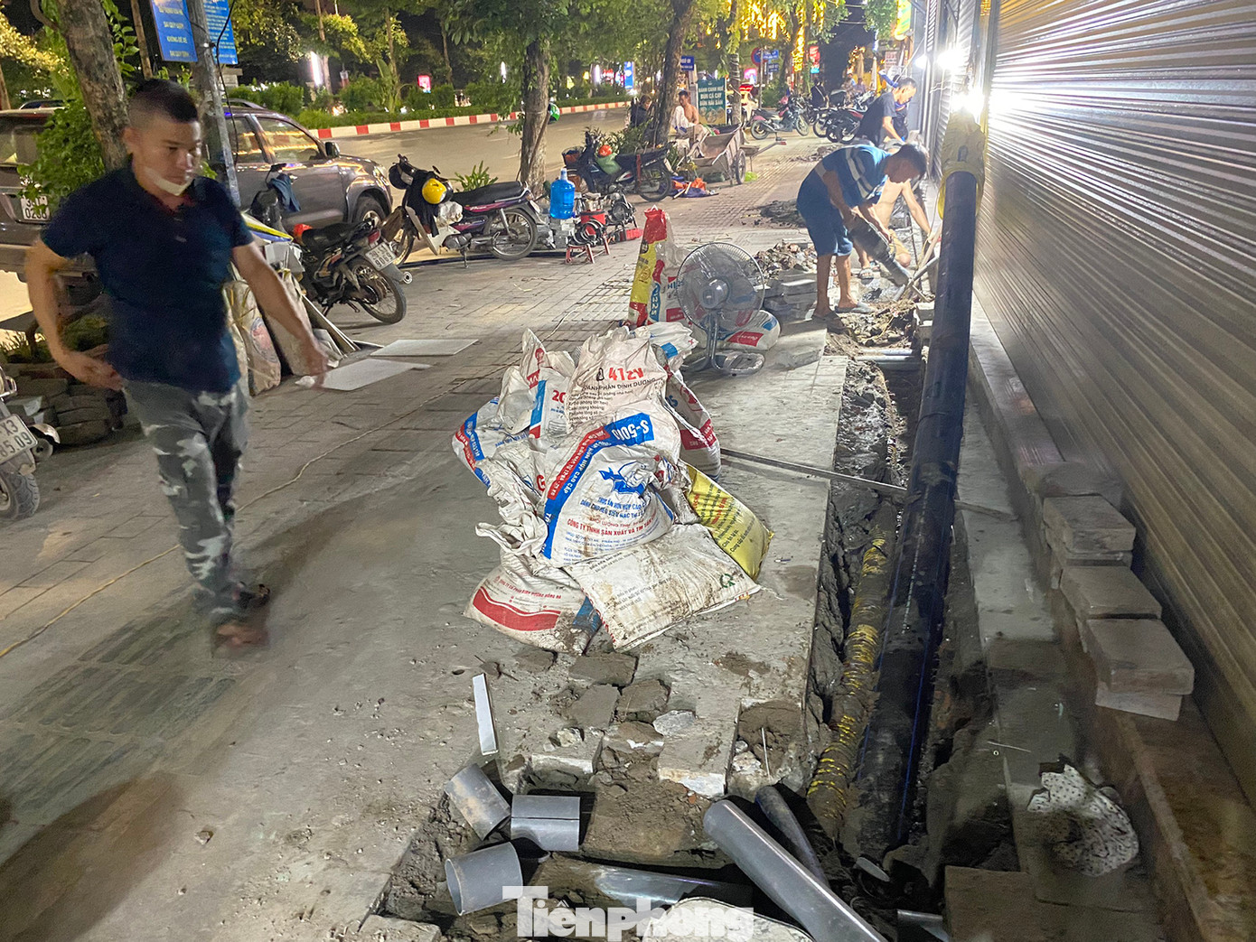 Tại phố Văn Cao (Ba Đình, Hà Nội) nhiều nhóm công nhân dùng máy đục, xà beng... cắt, phá kết cấu vỉa hè được lát đá tự nhiên để thi công cải tạo, sửa chữa đường ống nước. Ảnh: Trường Phong.